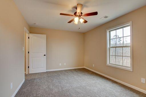 unfurnished room with carpet and ceiling fan