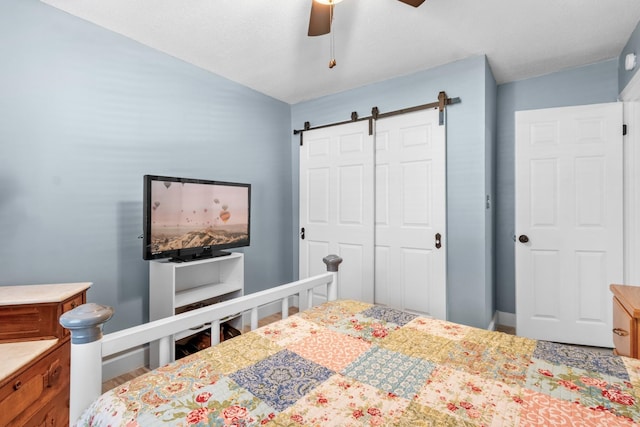 bedroom with a closet, a barn door, and ceiling fan