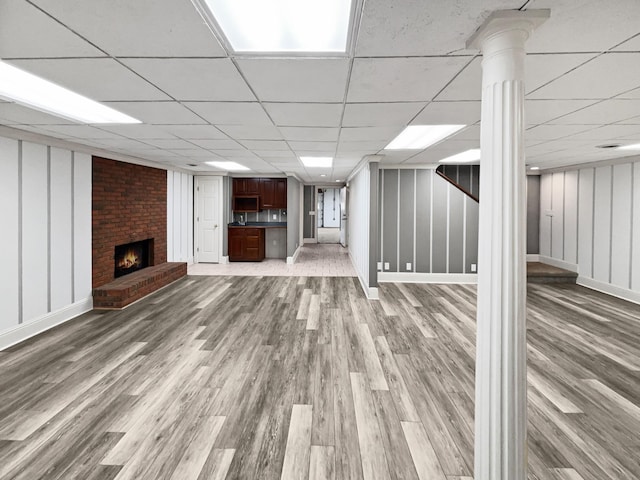 3556 Forest Park Rd, Springfield, TN 37172 - unfurnished living room with wood finished floors, a fireplace, a drop ceiling, decorative columns, and baseboards