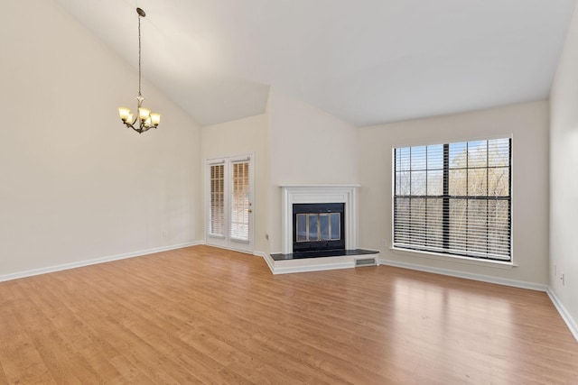 unfurnished living room featuring lofted ceiling, a notable chandelier, and light wood-type flooring