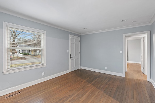 spare room with ornamental molding and dark hardwood / wood-style floors