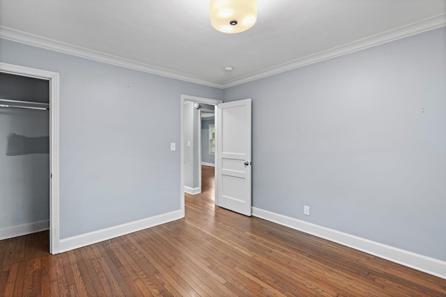 unfurnished bedroom featuring crown molding, wood-type flooring, and a closet