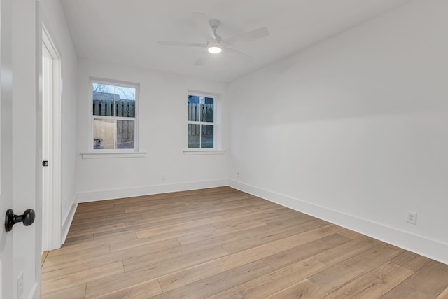 empty room featuring light wood-type flooring, baseboards, and a ceiling fan