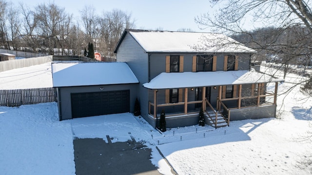 view of front facade featuring an attached garage, covered porch, and fence