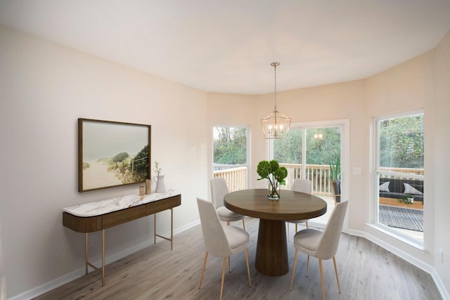 dining room featuring an inviting chandelier, a wealth of natural light, and light wood-type flooring