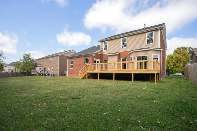 back of house with a wooden deck and a lawn