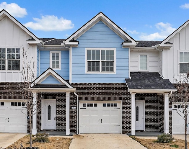 multi unit property featuring a shingled roof, concrete driveway, an attached garage, board and batten siding, and brick siding