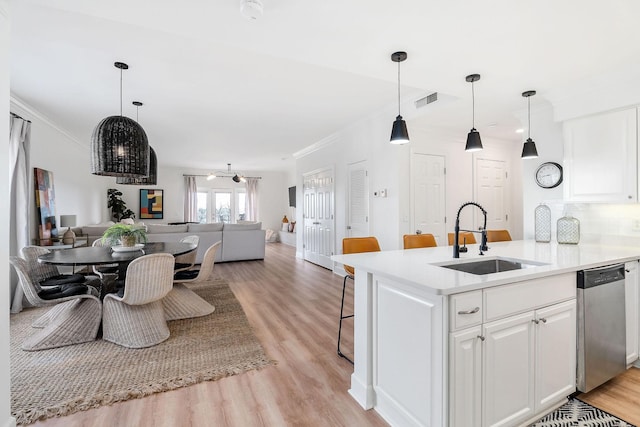 kitchen with pendant lighting, sink, stainless steel dishwasher, and white cabinets