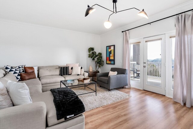 living room featuring french doors, crown molding, and light hardwood / wood-style flooring