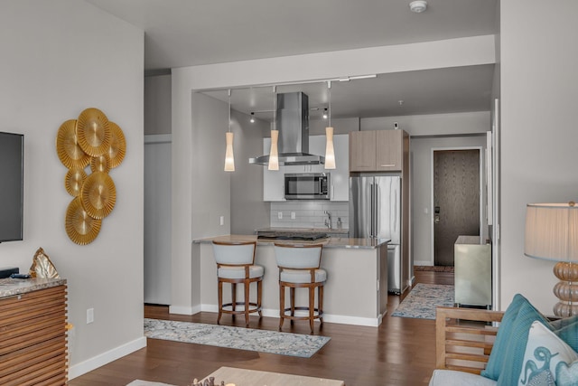 kitchen with backsplash, dark wood finished floors, ventilation hood, appliances with stainless steel finishes, and a peninsula