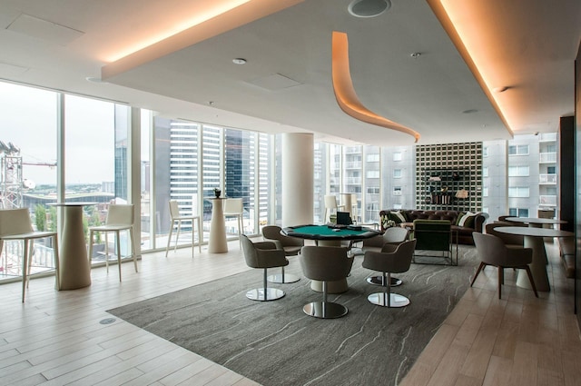 playroom featuring a wealth of natural light, pool table, a wall of windows, and wood finished floors