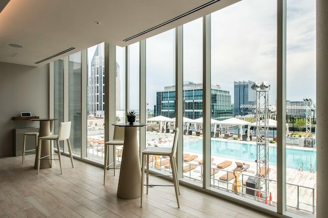 entryway with expansive windows, a city view, and wood finished floors