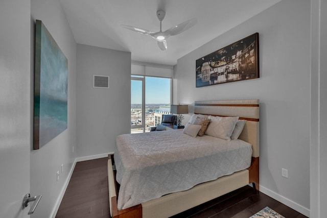 bedroom featuring visible vents, ceiling fan, baseboards, and wood finished floors