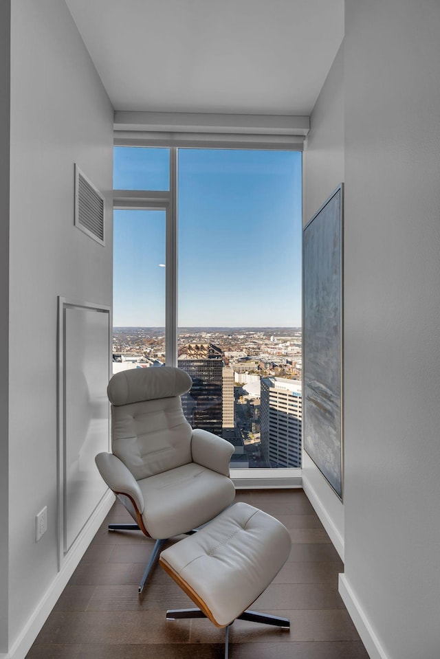 sitting room featuring visible vents, baseboards, and wood finished floors