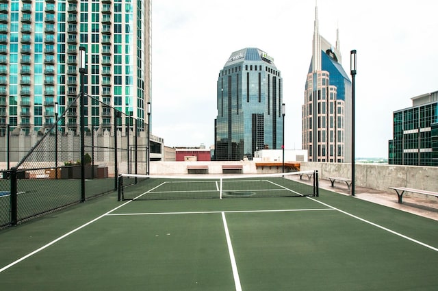 view of sport court with a city view and fence