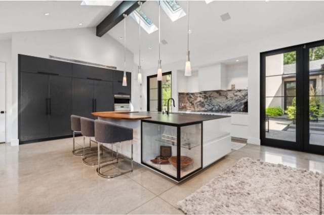 kitchen featuring hanging light fixtures, white cabinetry, a wealth of natural light, and a spacious island