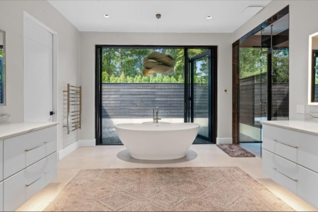 bathroom featuring vanity, a bath, and tile patterned floors