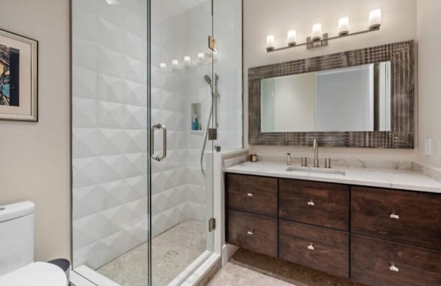 bathroom with vanity, an enclosed shower, and toilet