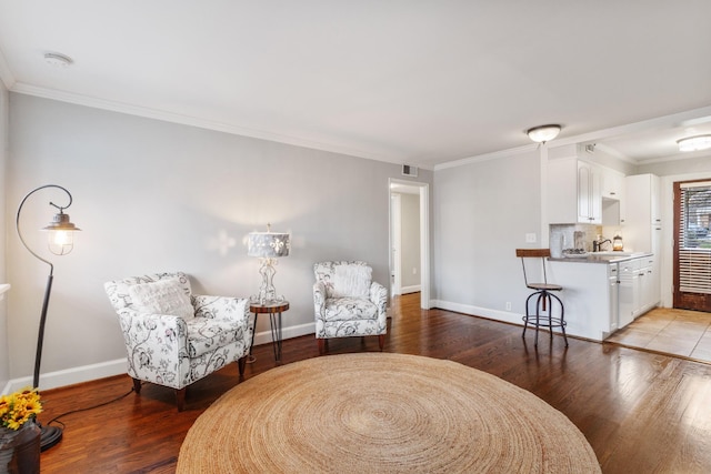 sitting room with ornamental molding, sink, and hardwood / wood-style floors