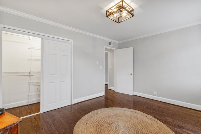 bedroom featuring crown molding, dark wood-type flooring, and a closet