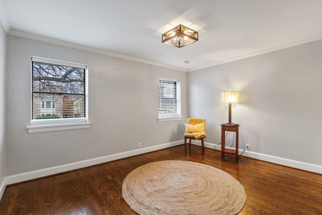 sitting room with crown molding and dark wood-type flooring