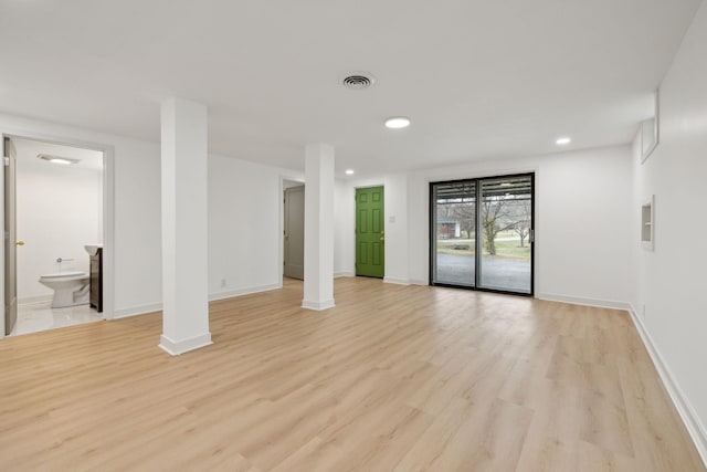 spare room featuring light wood finished floors, baseboards, and visible vents