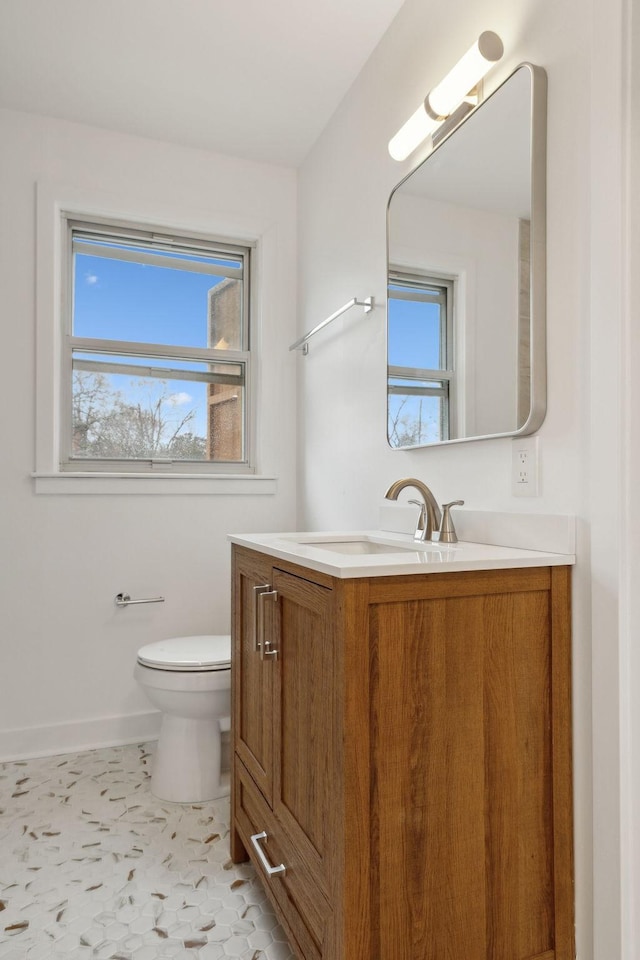 bathroom featuring baseboards, vanity, and toilet