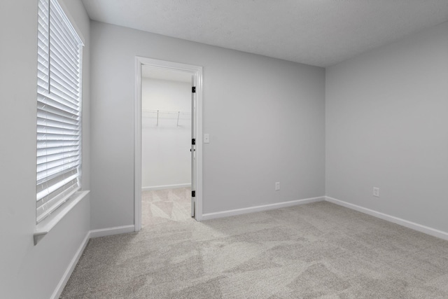 carpeted empty room featuring a textured ceiling