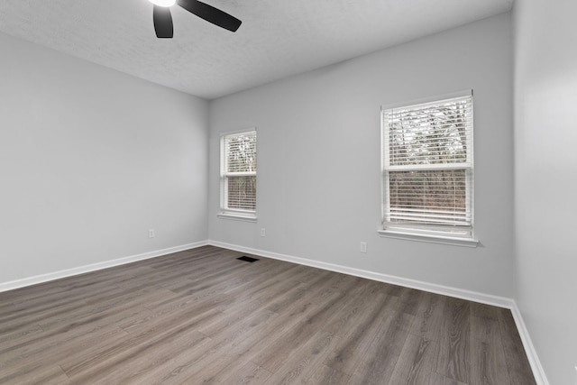 spare room featuring hardwood / wood-style flooring, ceiling fan, and a textured ceiling