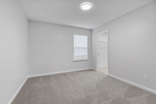 unfurnished room featuring carpet floors and a textured ceiling