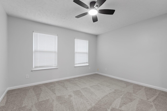 unfurnished room featuring ceiling fan, light carpet, and a textured ceiling