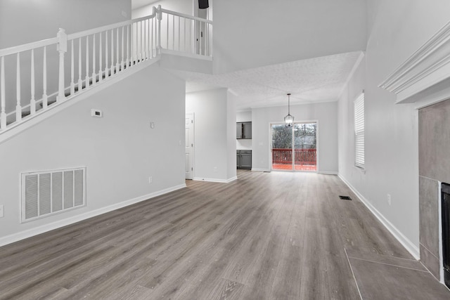 unfurnished living room featuring wood-type flooring and a high ceiling