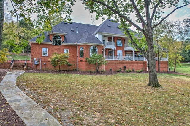 exterior space with a balcony and a front lawn