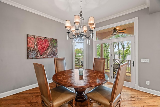 dining area with crown molding, ceiling fan with notable chandelier, and hardwood / wood-style flooring