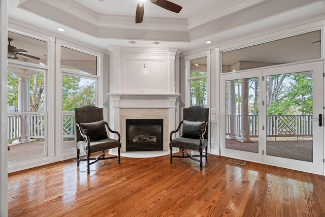 sitting room featuring crown molding, a tray ceiling, and hardwood / wood-style flooring