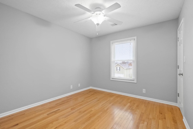 empty room with ceiling fan, light hardwood / wood-style flooring, and a textured ceiling