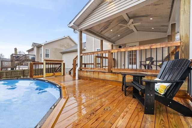 deck with a fenced in pool and ceiling fan