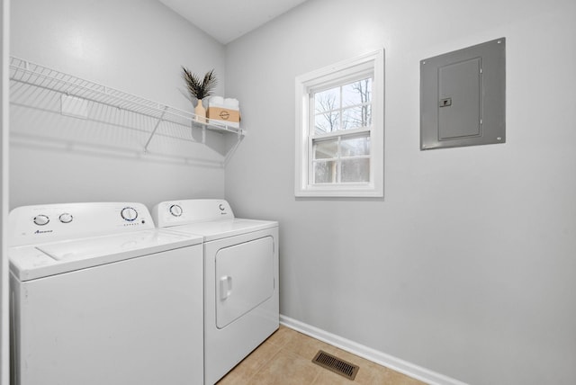 clothes washing area featuring light tile patterned floors, washer and clothes dryer, and electric panel