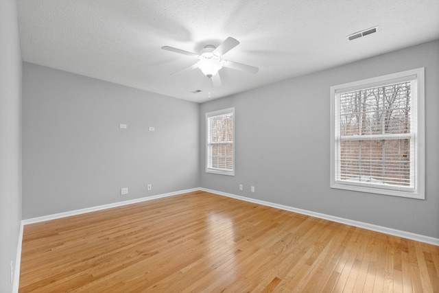 unfurnished room with a textured ceiling, light hardwood / wood-style flooring, and ceiling fan