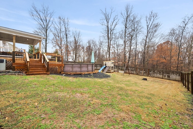 view of yard featuring central AC unit, a fenced in pool, and a playground