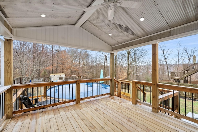 wooden deck featuring a pool and ceiling fan