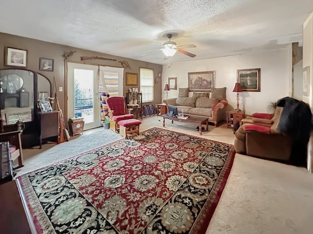 living room featuring ceiling fan, carpet floors, and a textured ceiling