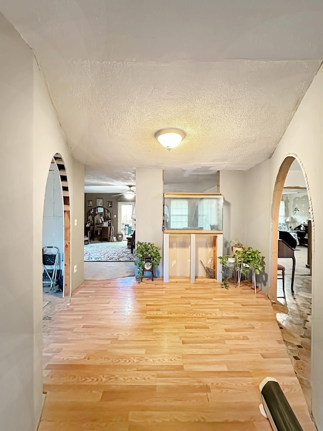 hallway featuring wood-type flooring and a textured ceiling