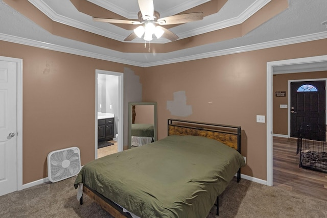 bedroom featuring crown molding, carpet flooring, connected bathroom, and a tray ceiling