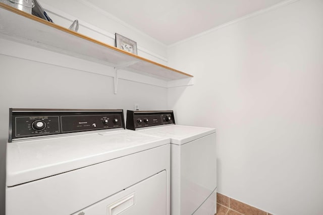 washroom with washing machine and clothes dryer, ornamental molding, and light tile patterned floors