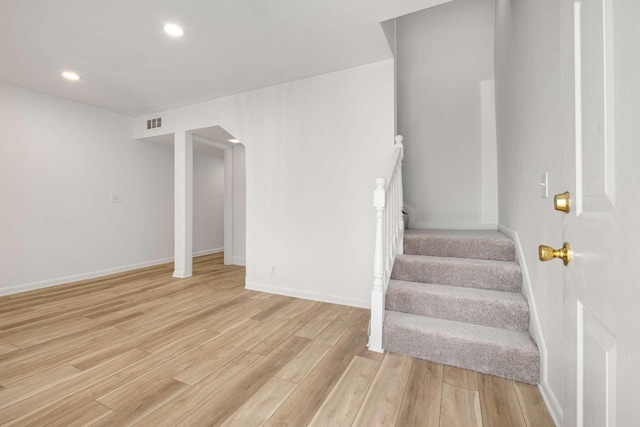 staircase with hardwood / wood-style floors