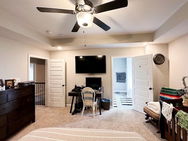 bedroom with a raised ceiling and light carpet