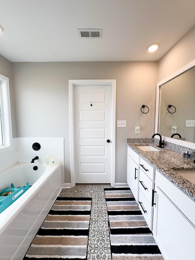 bathroom featuring vanity and a washtub