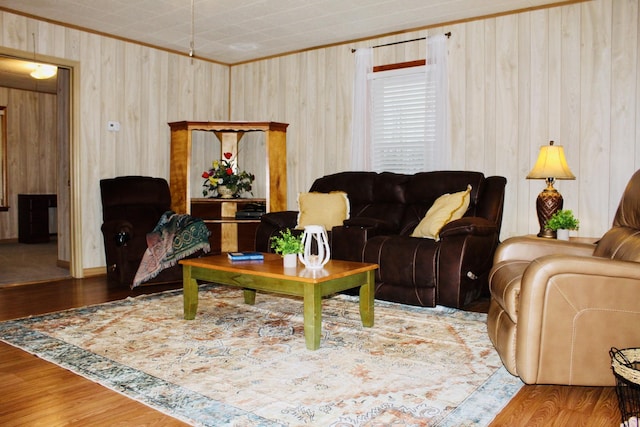 living room with hardwood / wood-style flooring, crown molding, and wooden walls