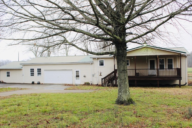 back of property featuring a garage and a yard